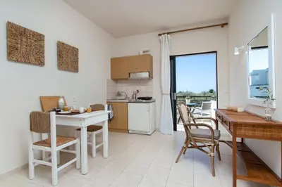 a kitchen and dining room with a table and chairs at Kanso Rooms in Galatás
