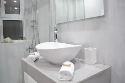 a white bathroom with a bowl sink on a counter at MV House Agia Marina in Agia Marina Nea Kydonias