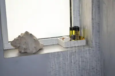 a window sill with a rock and two bottles on it at MV House Agia Marina in Agia Marina Nea Kydonias