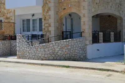 a stone wall in front of a building at MV House Agia Marina in Agia Marina Nea Kydonias