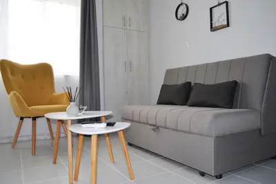 a living room with a couch and two tables at MV House Agia Marina in Agia Marina Nea Kydonias