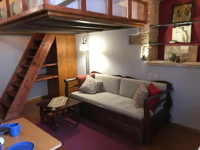 a living room with a couch and a loft bed at Microcosmos Halepas in Chania Town