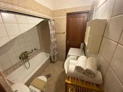 a bathroom with a toilet and a tub with towels at Microcosmos Halepas in Chania Town