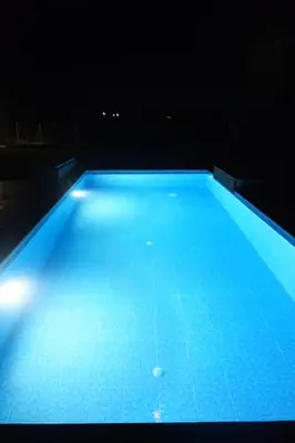 a large blue swimming pool at night at Sea Lake Holiday House in Elafonisi