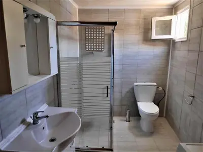a bathroom with a shower and a toilet and a sink at Sea Lake Holiday House in Elafonisi