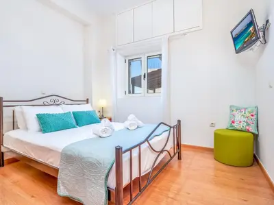 a bedroom with a large bed with blue pillows at Casteli Stone Residence in Kissamos