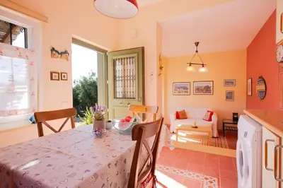a kitchen and living room with a table and a couch at MaGea- Asterias Ground floor peaceful apartment in Tavronitis