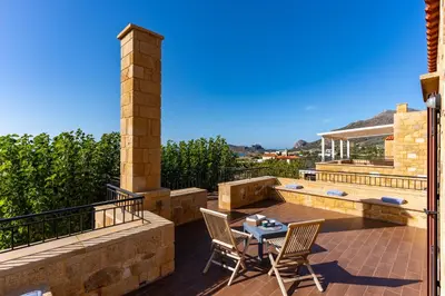 a patio with a table and chairs on a balcony at Stay in Falassarna Villas in Falasarna