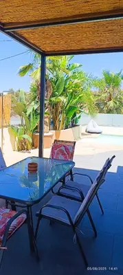 a glass table and chairs on a patio at Chania Olive Home in Kato Daratso
