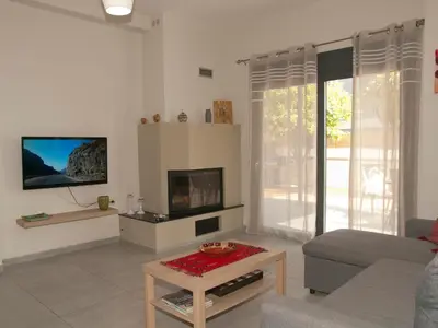 a living room with a couch and a fireplace at Chania Olive Home in Kato Daratso