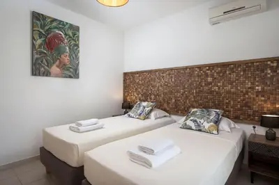 two beds in a room with white sheets at Villa La Palma in Vrísai
