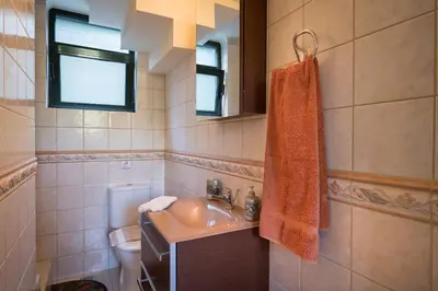 a bathroom with a sink and a toilet at Villa La Palma in Vrísai