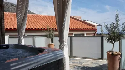 a balcony with a hot tub and two potted plants at Arhondiko Luxury House in Sougia