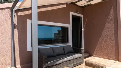 a screened in porch with a couch in front of a window at Arhondiko Luxury House in Sougia