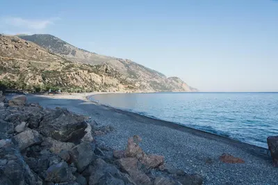 a beach with some rocks and the water at Arhondiko Luxury House in Sougia
