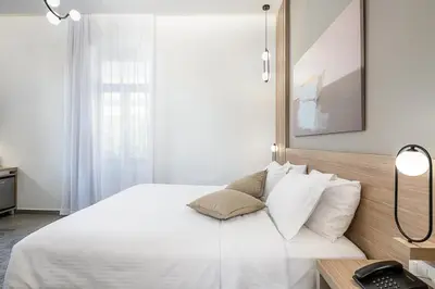 a bedroom with a white bed and a desk with a phone at Epavli Boutique Hotel in Chania Town