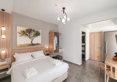 a bedroom with a large white bed and a table at Epavli Boutique Hotel in Chania Town