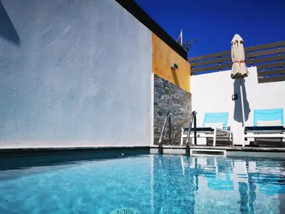 a swimming pool with two chairs and an umbrella at Villa Patroklos in Daratso