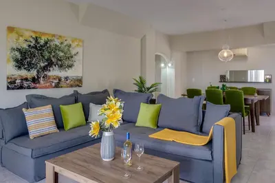 a living room with a blue couch and a table at Chania Elite Homes, Enjoy a Chic Oasis by the heated Pool in Kounoupidhianá