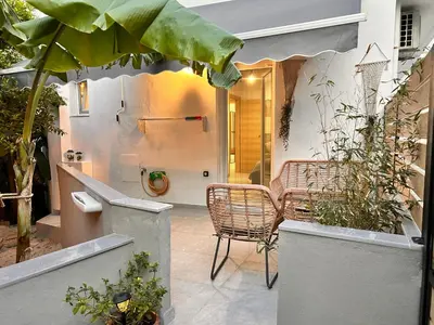 a patio with a table and chairs and plants at Evis House in Chania Town