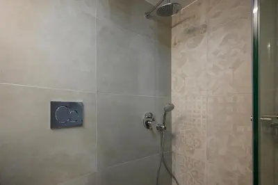 a bathroom with a shower with the olympics on the wall at Penny's Old Town Houses in Chania Town
