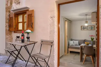 a room with a table and chairs and a couch at Penny's Old Town Houses in Chania Town