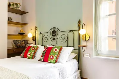 a bedroom with a bed with red and green pillows at Chanialiving Venetian Luxury House-near Plaza Parking in Chania Town