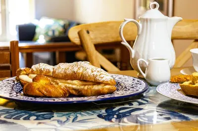 a plate of pastries on a table with a tea kettle at Chanialiving Venetian Luxury House-near Plaza Parking in Chania Town