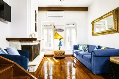 a living room with blue couches and a fireplace at Chanialiving Venetian Luxury House-near Plaza Parking in Chania Town