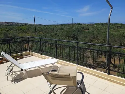 a balcony with a chair and a bath tub on a roof at Manolo s olive farm, apartment with seaview in Chania Town