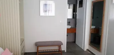 a small bathroom with a stool and a mirror at Rotunda Suites in Kalamaki Chanion