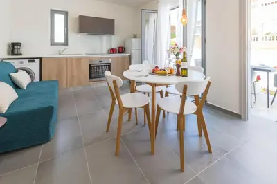 a kitchen and living room with a table and chairs at Rotunda Suites in Kalamaki Chanion