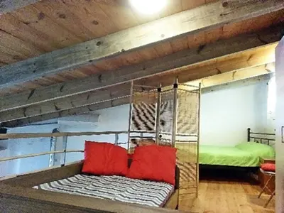 a bunk bed with red pillows in a room at apartment over the sea Private place to swim in Ravdhoúkha