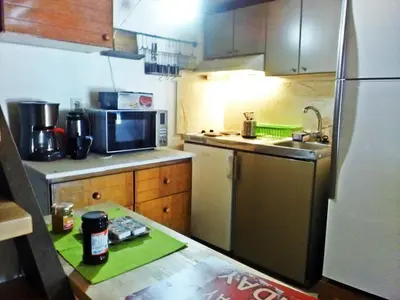 a kitchen with a stainless steel refrigerator and a sink at apartment over the sea Private place to swim in Ravdhoúkha