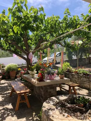 a garden with a table and benches and potted plants at Elia's House Traditional & Cozy by 8essentially in Kalyves
