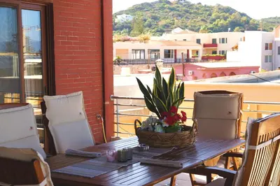 a wooden table with a plant on a balcony at Double View Apartment in Agia Marina Nea Kydonias