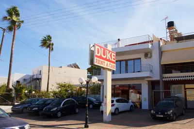 a sign for a drug store with cars parked in a parking lot at Double View Apartment in Agia Marina Nea Kydonias