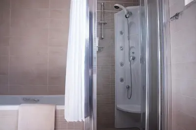 a bathroom with a shower and a bath tub at Double View Apartment in Agia Marina Nea Kydonias