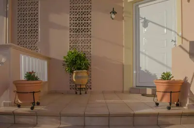 a porch with two potted plants in front of a door at Villa Aretaki in Kalamaki Chanion
