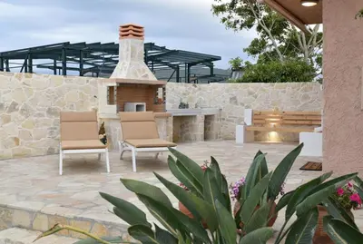 a patio with two chairs and a stone fireplace at House near Balos in Kissamos in Kissamos