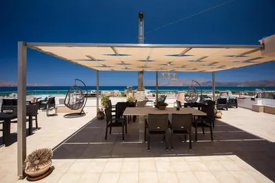 a patio with a table and chairs and the ocean at Anastellar in Kissamos