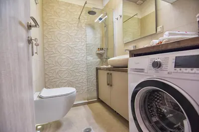 a bathroom with a washing machine and a toilet at Pasiphae New Apartment sea & city in Chania Town