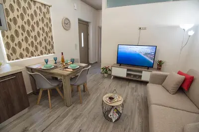 a living room with a couch and a table with a television at Pasiphae New Apartment sea & city in Chania Town