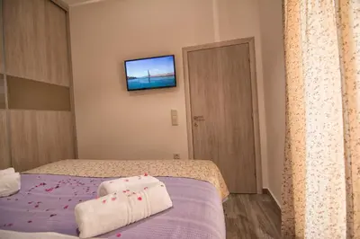 a bedroom with a bed and a tv on the wall at Pasiphae New Apartment sea & city in Chania Town