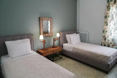 a bedroom with two beds and a mirror and a table at Casa Armada in Chania Town