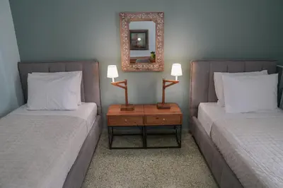 a bedroom with two beds and a mirror on the wall at Casa Armada in Chania Town