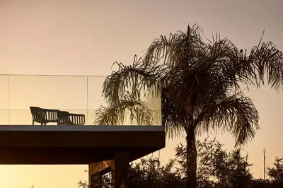 a palm tree and a bench in front of a building at Villa Fuerte & Weddings Estate in Alikianós