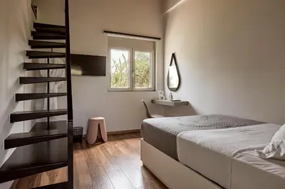 a bedroom with a bed and a spiral staircase at Villa Fuerte & Weddings Estate in Alikianós