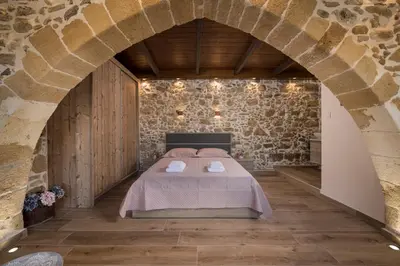 a bedroom with a bed in a stone wall at Doro Villas in Kissamos