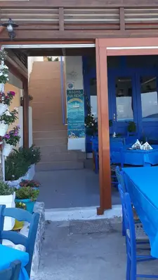 a group of blue tables and chairs in front of a building at Christos Rooms in Palaiochóra